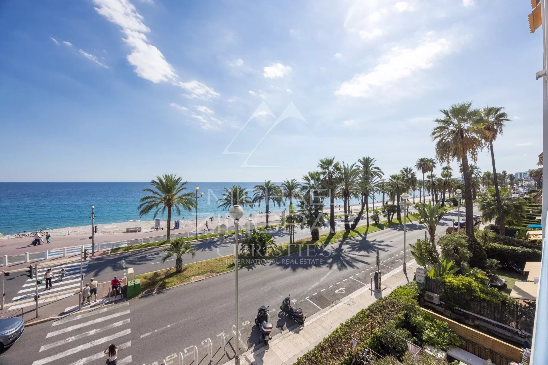 View of the Promenade des Anglais in Nice View of the Promenade des Anglais and the sea in Nice, with palm trees and cars on the road.
