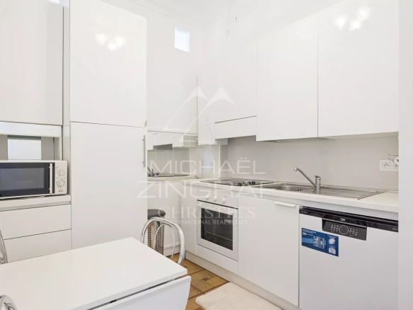 Modern and bright kitchen in an apartment in Nice, with white furniture and integrated appliances.