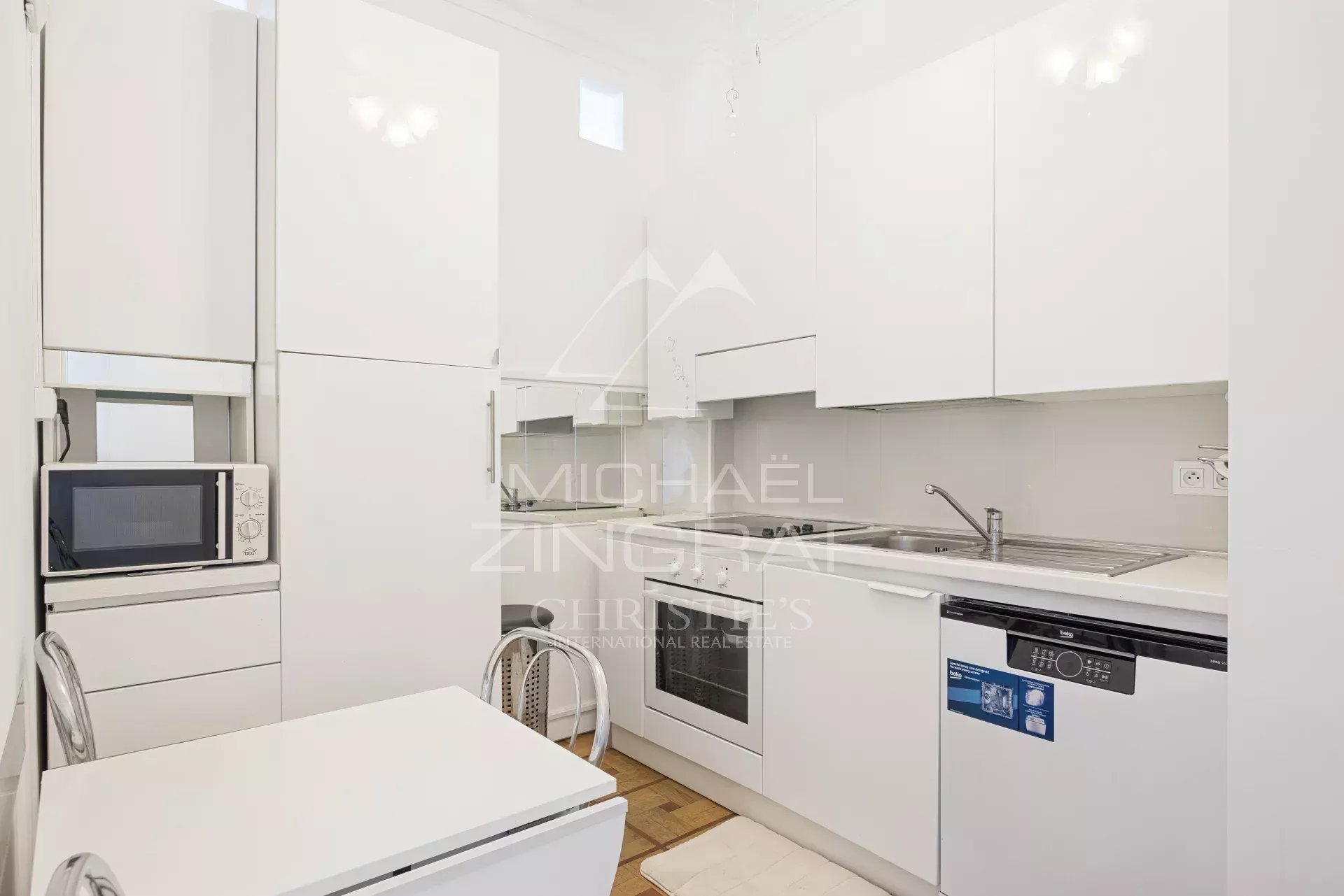 Kitchen of an apartment in Nice Modern and bright kitchen in an apartment in Nice, with white furniture and integrated appliances.