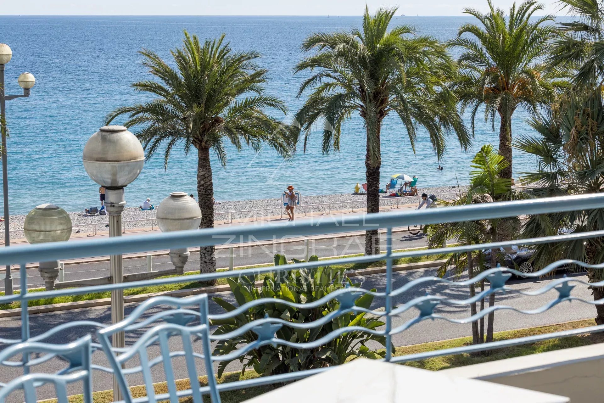 Sea view from a terrace in Nice View of the Mediterranean Sea from a terrace with palm trees and a beach in Nice.