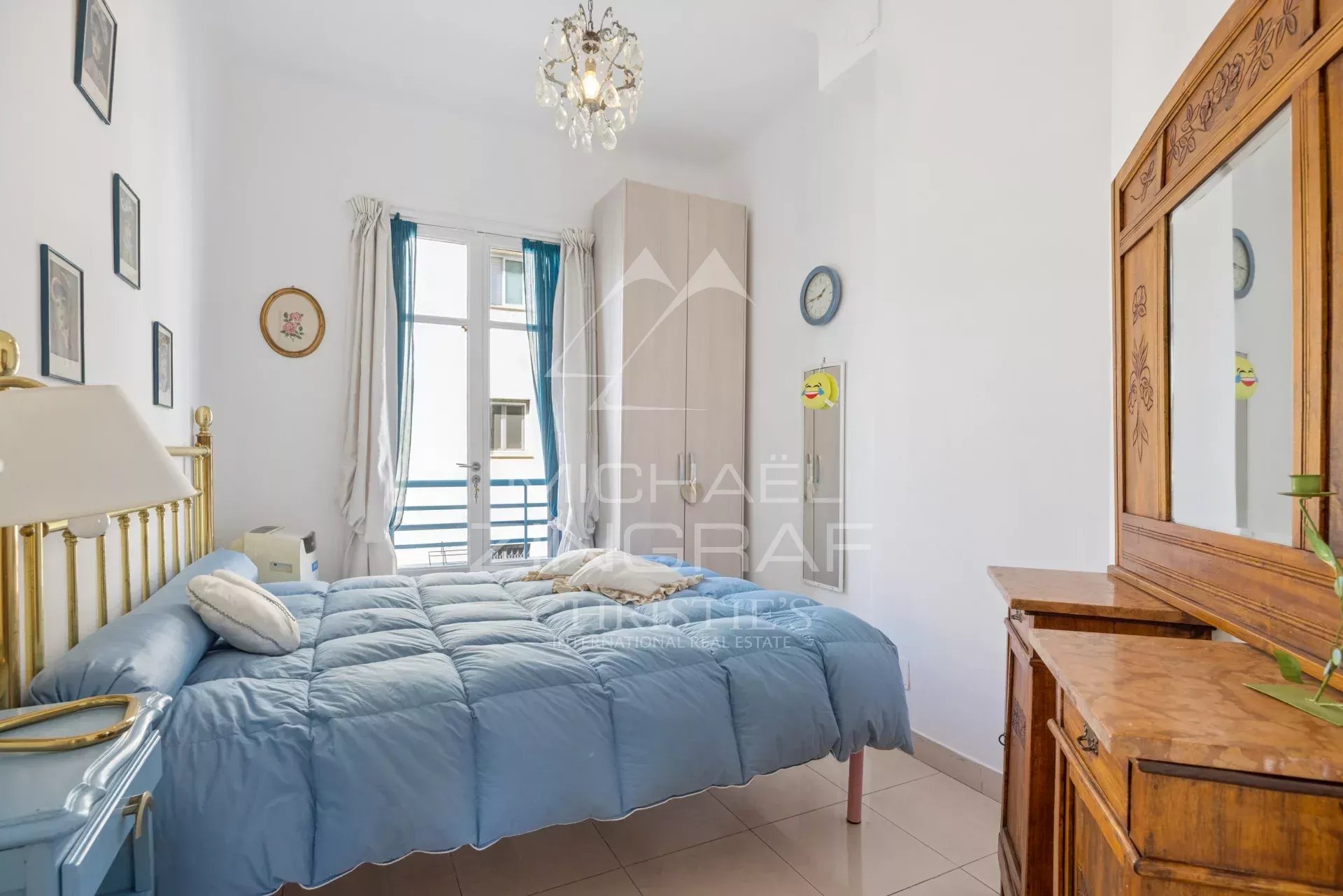 Apartment room in Nice Apartment room with bed, wooden furniture and window overlooking a balcony.