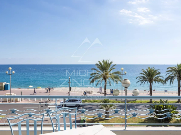 Sea view from an apartment terrace in Nice, with palm trees and the Promenade des Anglais in the background.