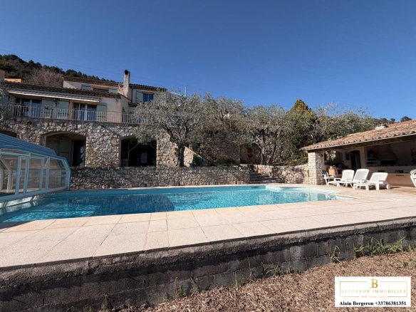 Villa avec piscine et vue panoramique à Spéracèdes, entourée d'arbres et de pierres.