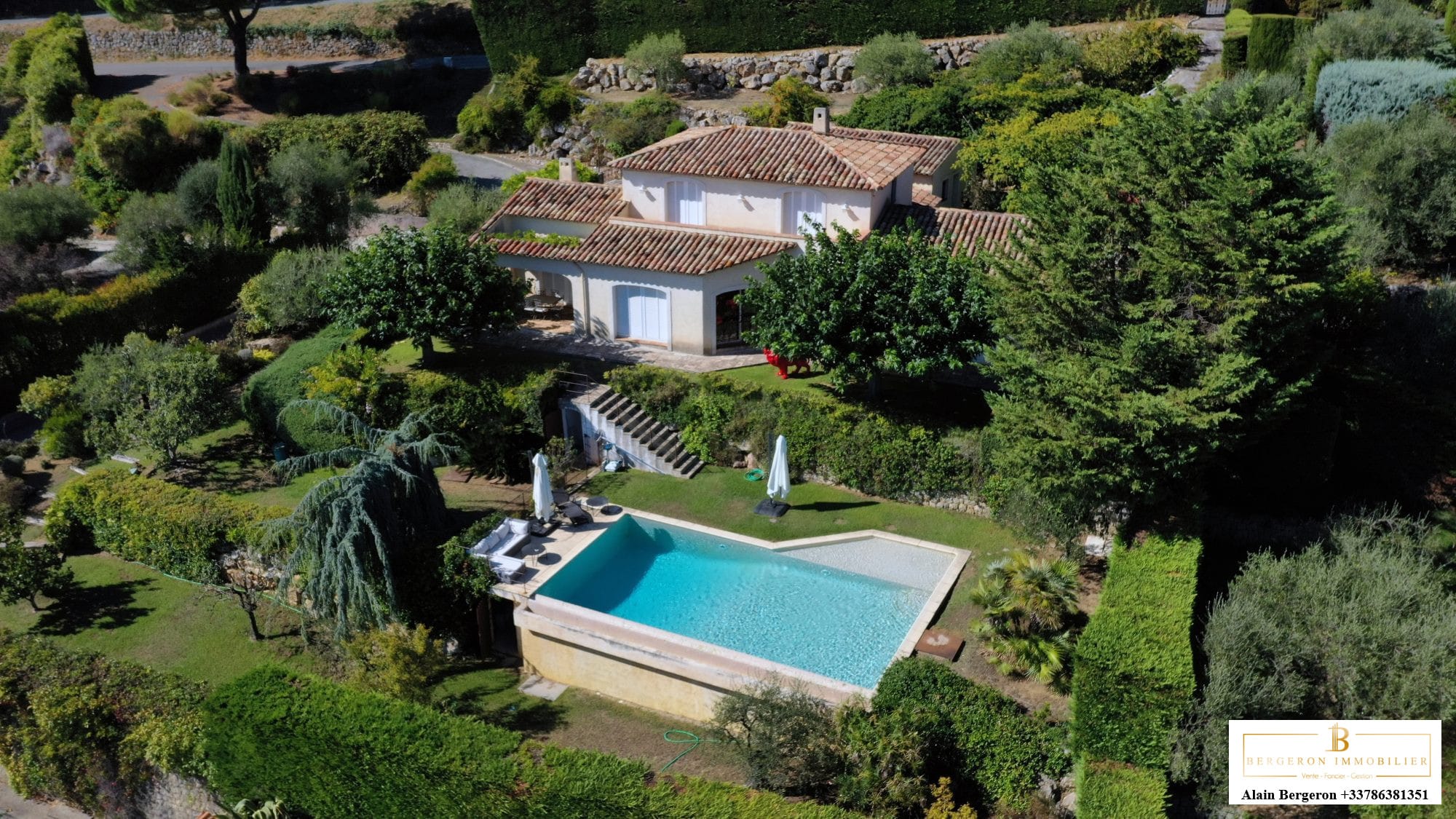 Vue aérienne d'une villa avec piscine à Cabris, entourée de verdure.