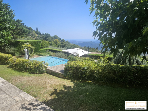 View of a villa with swimming pool and garden in Cabris, sunny with a panoramic view.