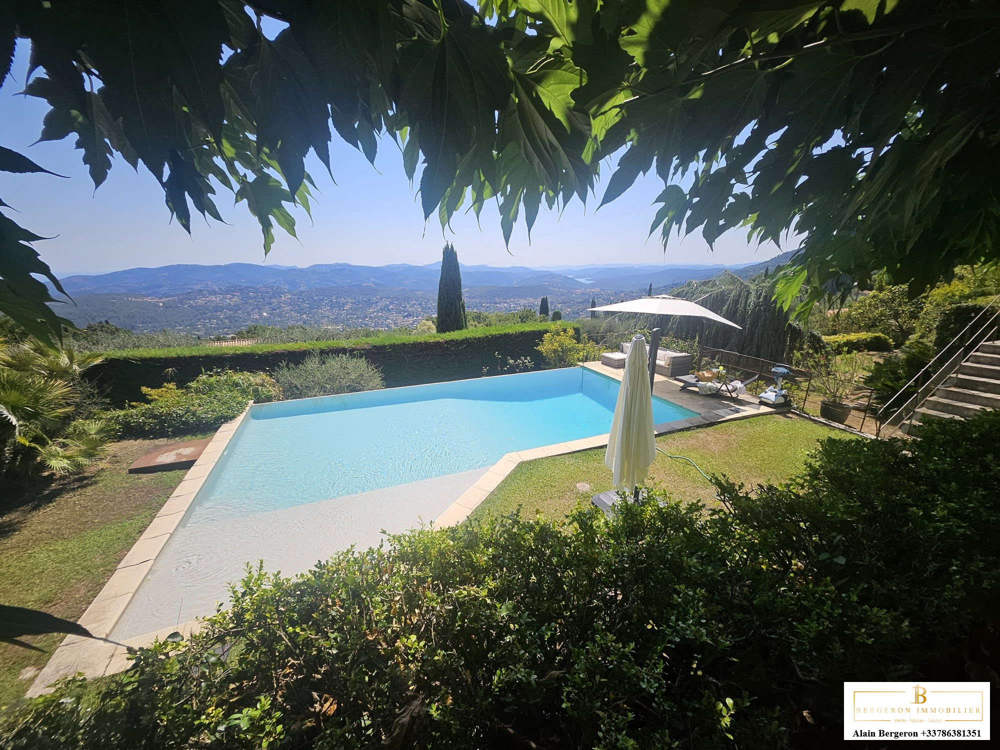 Luxury villa in Cabris View of the pool and garden of the villa in Cabris, with mountains in the background.