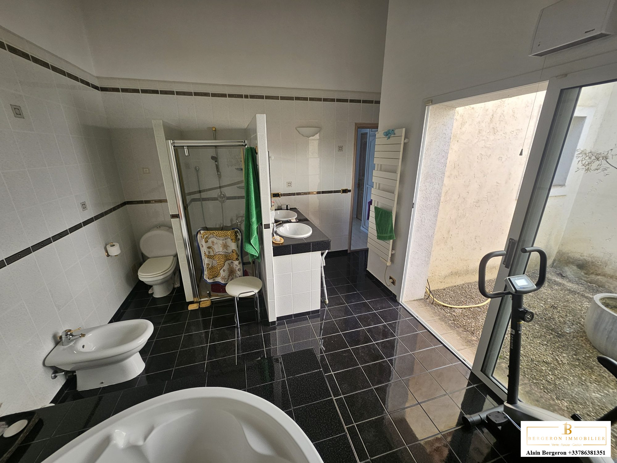 Bathroom of the villa in Cabris Modern bathroom with bathtub and shower, black and white tiles.