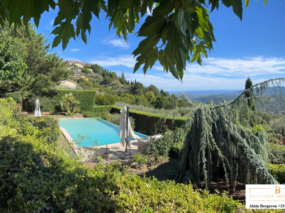 View of a villa with swimming pool and garden in Cabris, surrounded by greenery and hills.