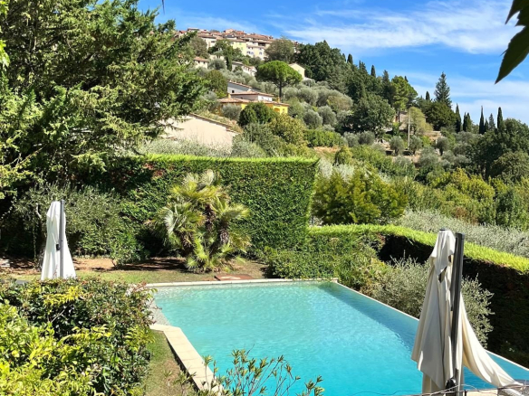 View of a villa with a swimming pool surrounded by greenery in Cabris.
