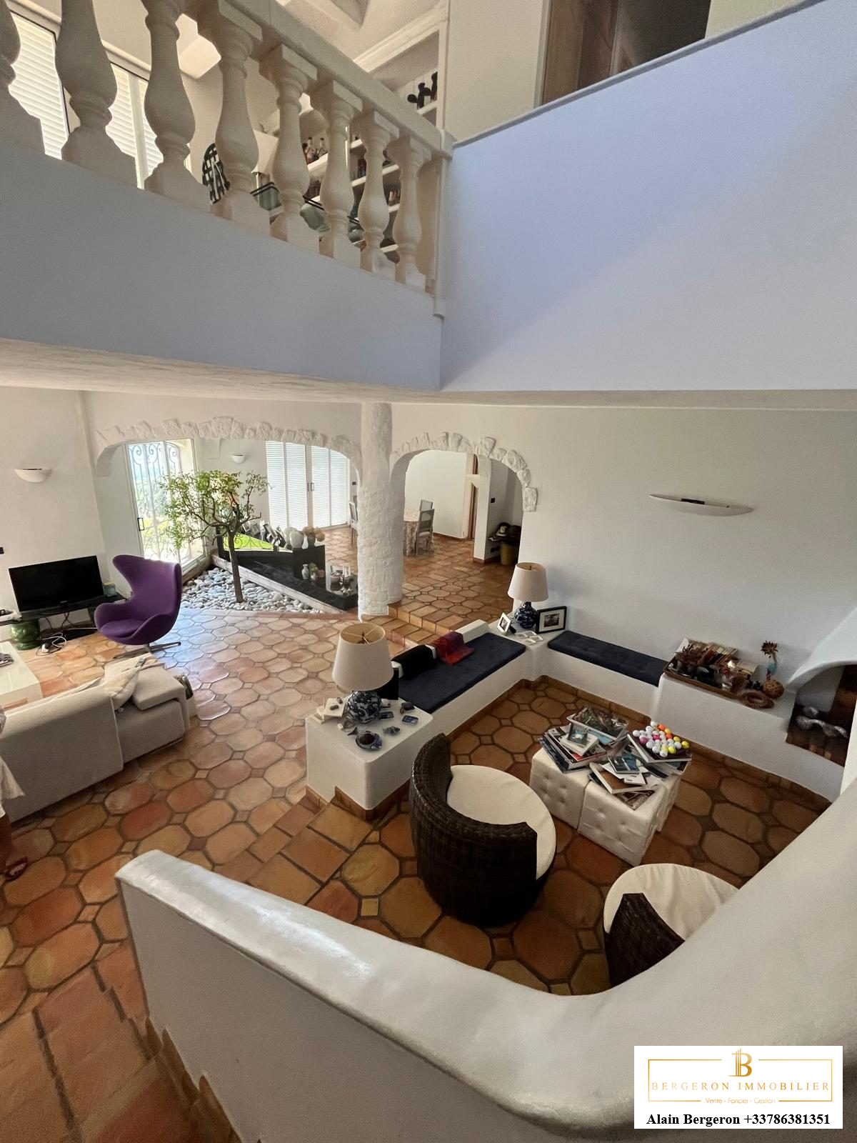 Interior of a villa in Cabris Interior of a modern villa with a large, bright living room and terracotta tile flooring.