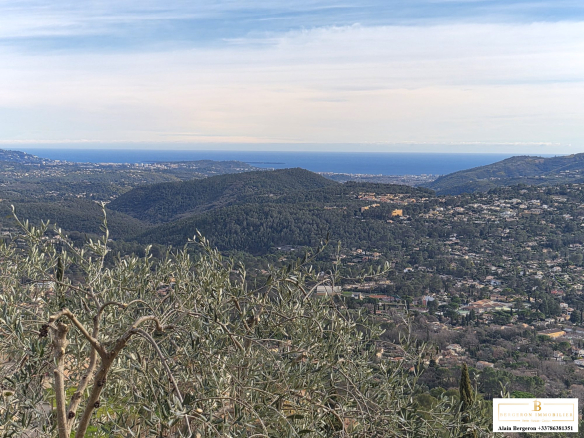 Vue panoramique depuis une villa à Spéracèdes, avec des collines et la mer en arrière-plan.