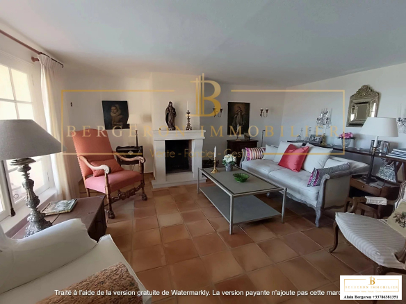 Intérieur d'une villa avec salon lumineux et cheminée, décor moderne et classique.