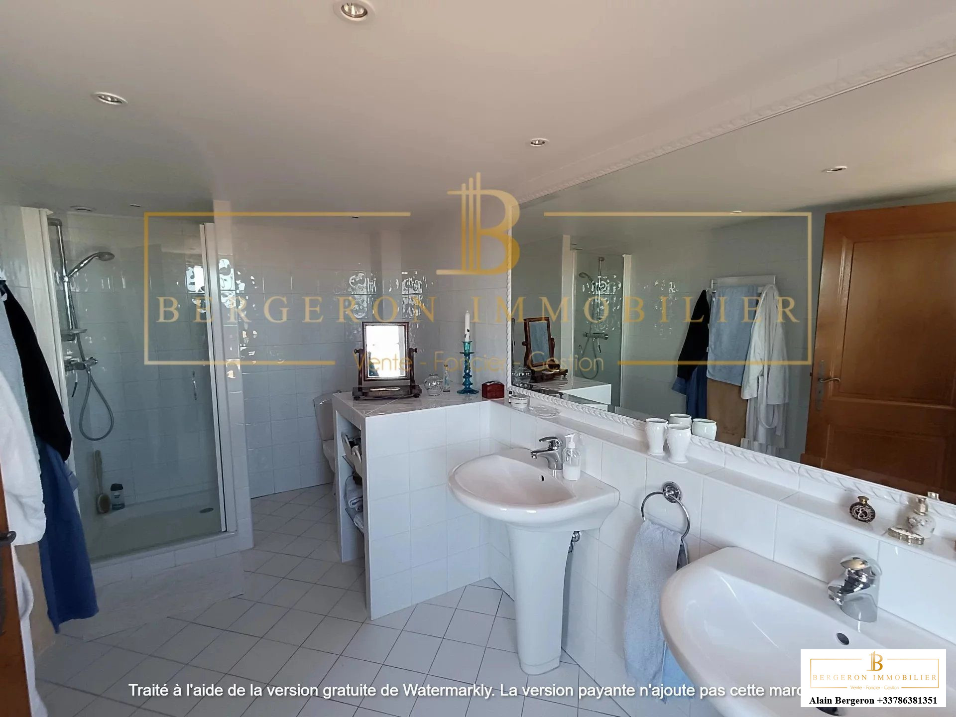 Salle de bain spacieuse avec deux lavabos et douche, éclairée par la lumière naturelle.