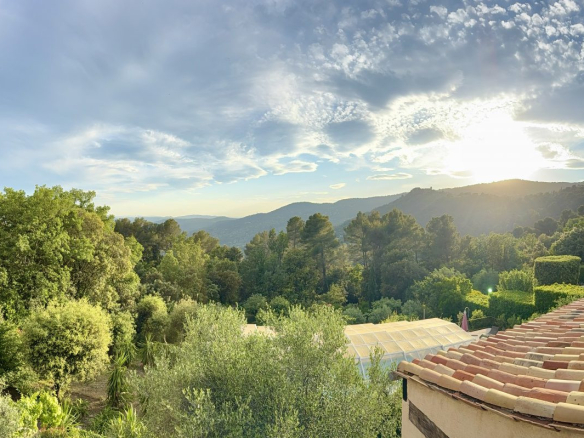 Vue panoramique sur la nature depuis une maison à Cabris, avec des arbres et un ciel nuageux.