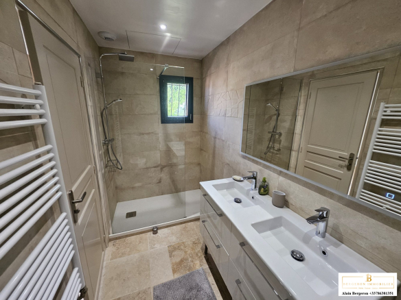 Salle de bain moderne avec douche à l'italienne et double vasque.