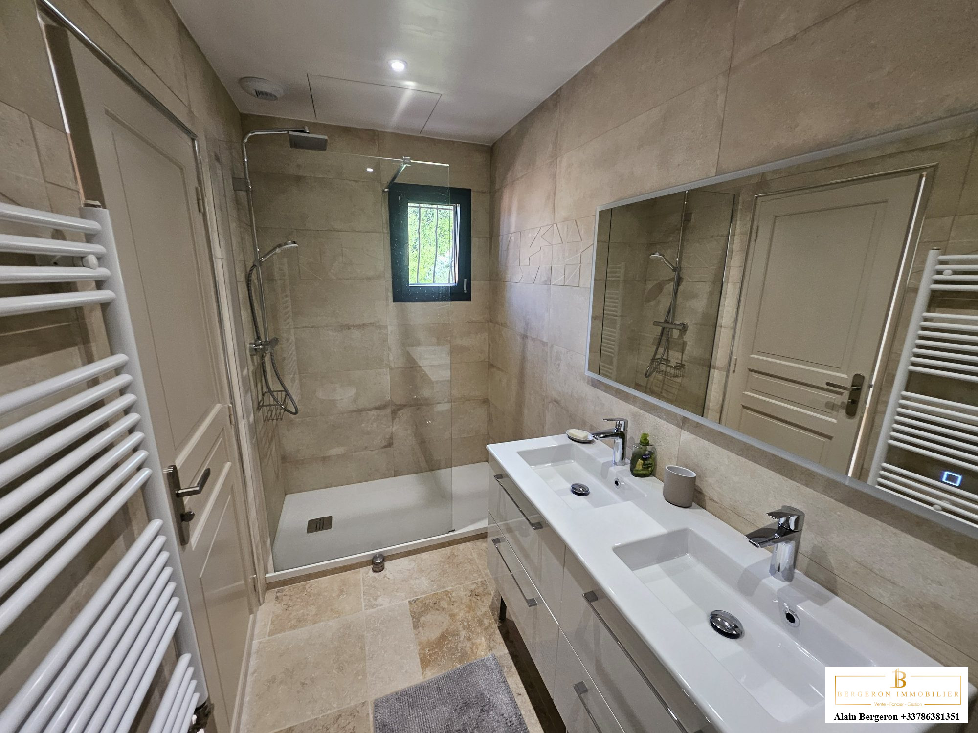 Salle de bain moderne avec douche à l'italienne et double vasque.