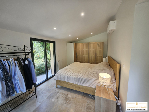 Chambre spacieuse avec lit double et rangement à Cabris, éclairage moderne.