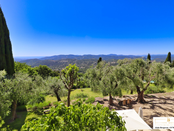 Vue panoramique sur un jardin méditerranéen avec des oliviers et des collines en arrière-plan à Cabris.