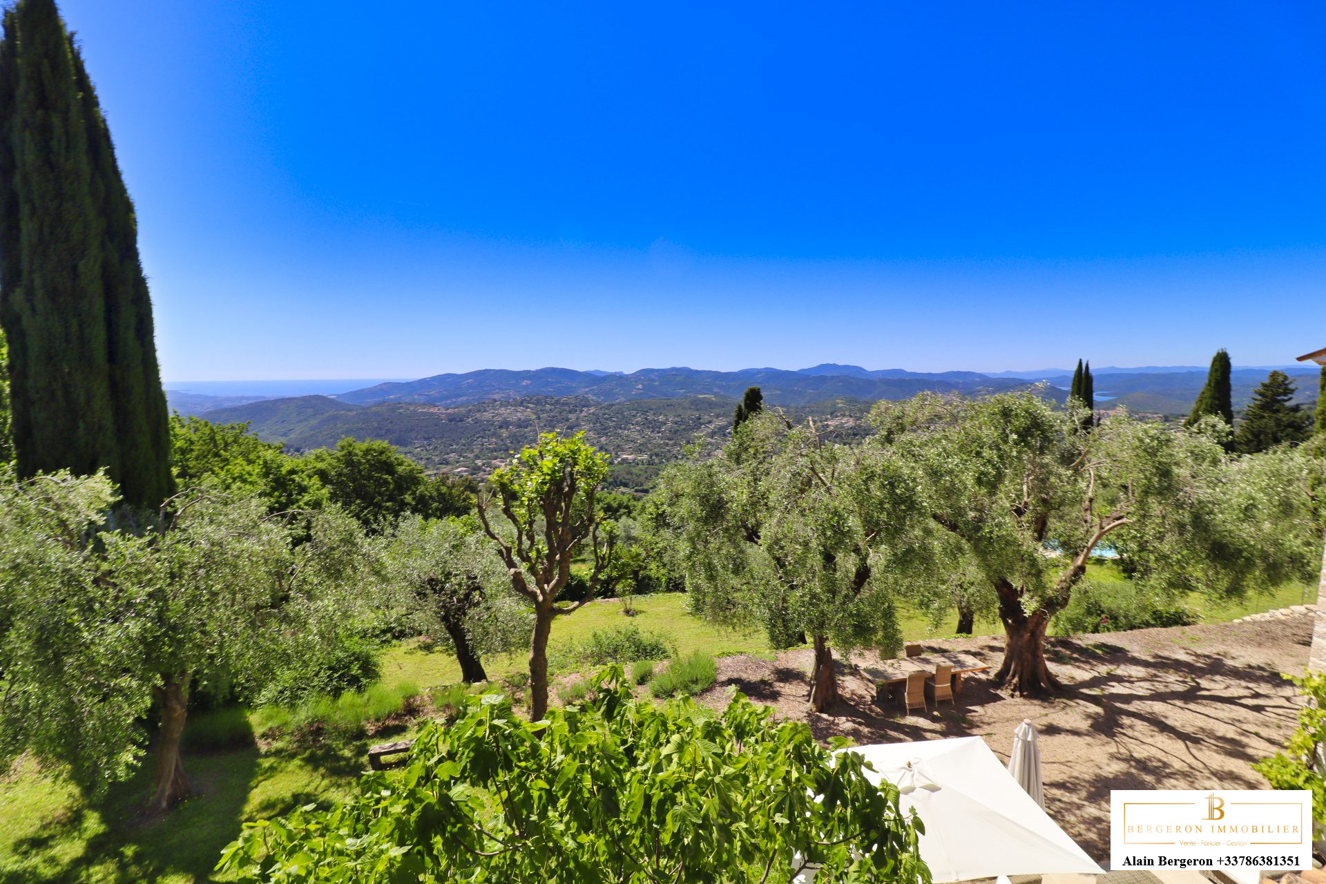 Bastide d’exception à Cabris Vue panoramique sur un jardin méditerranéen avec des oliviers et des collines en arrière-plan à Cabris.