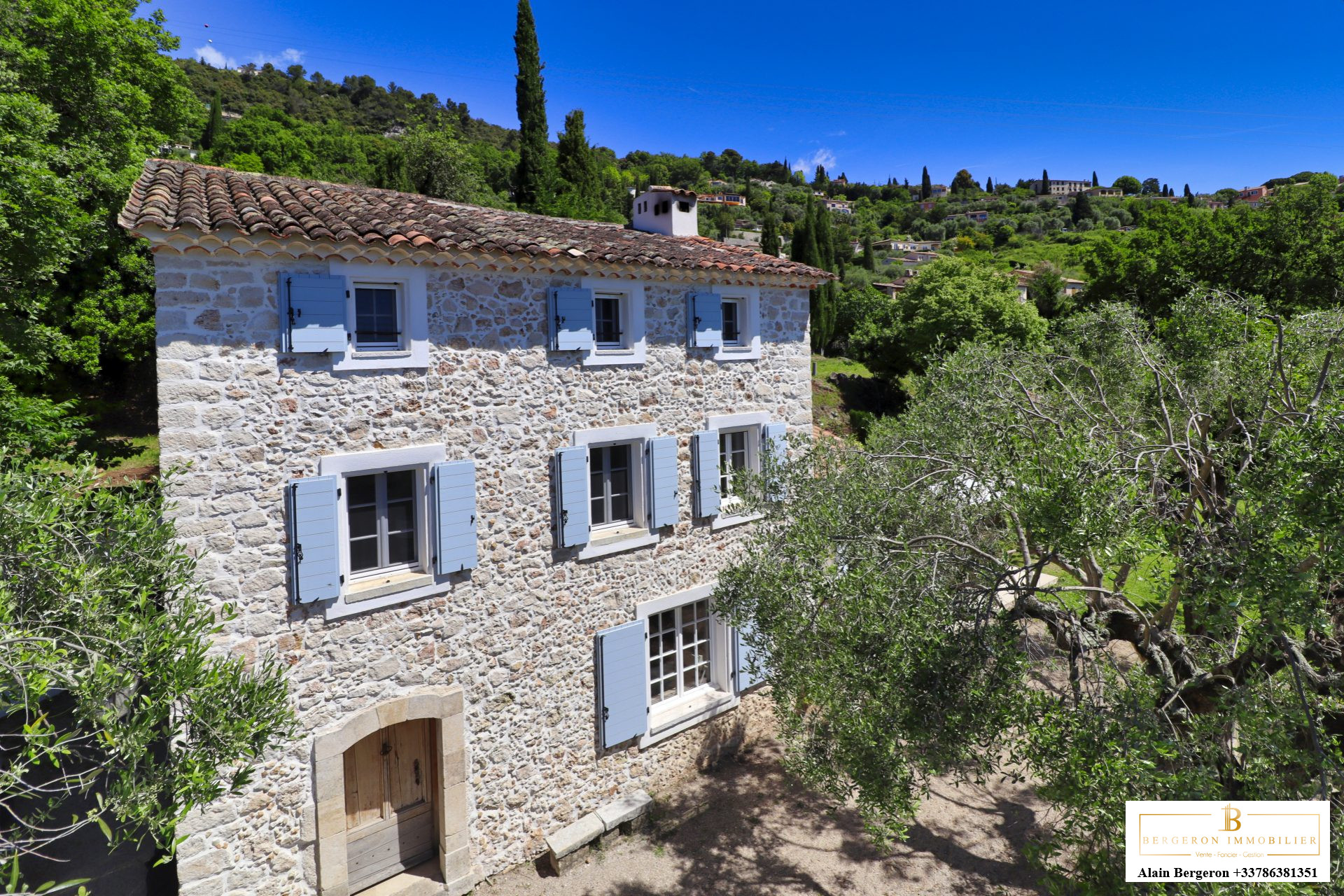 Bastide Provençale à Cabris Bastide provençale en pierre avec volets bleus, entourée d'un jardin méditerranéen à Cabris.