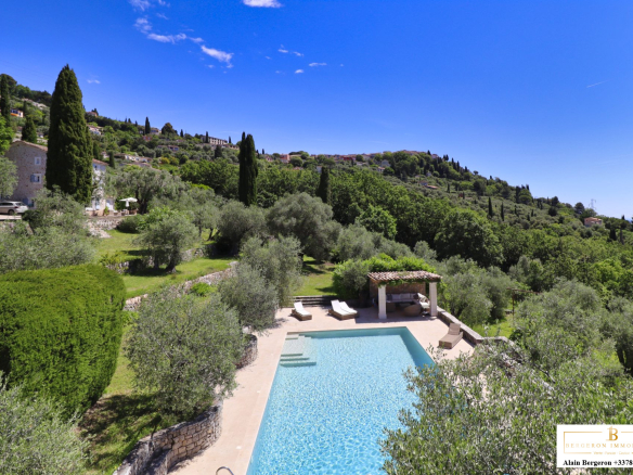 Vue d'une bastide provençale avec piscine et jardin méditerranéen à Cabris.