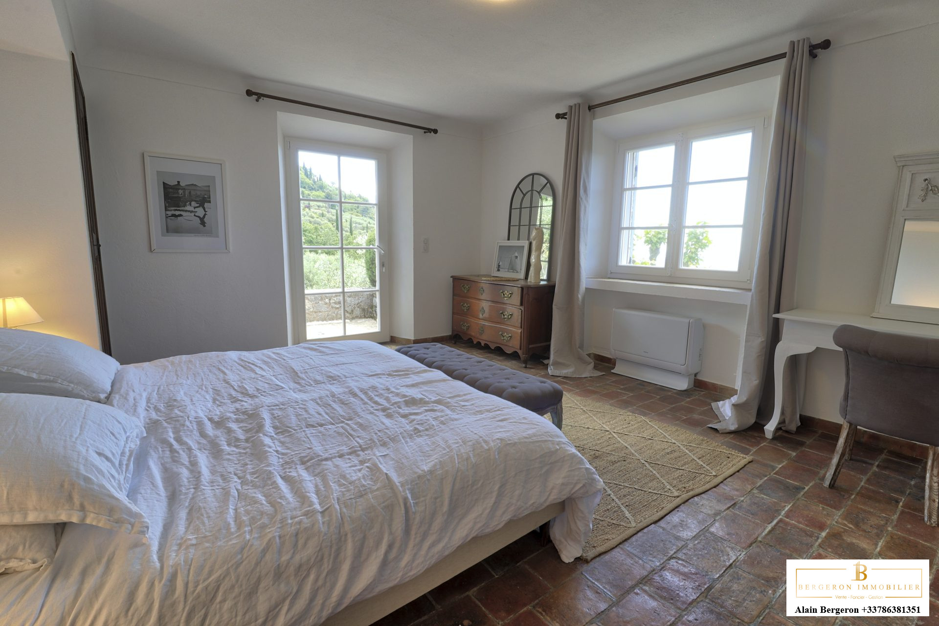 Chambre d’une bastide provençale Chambre lumineuse d'une bastide provençale avec lit, fenêtre et mobilier élégant.