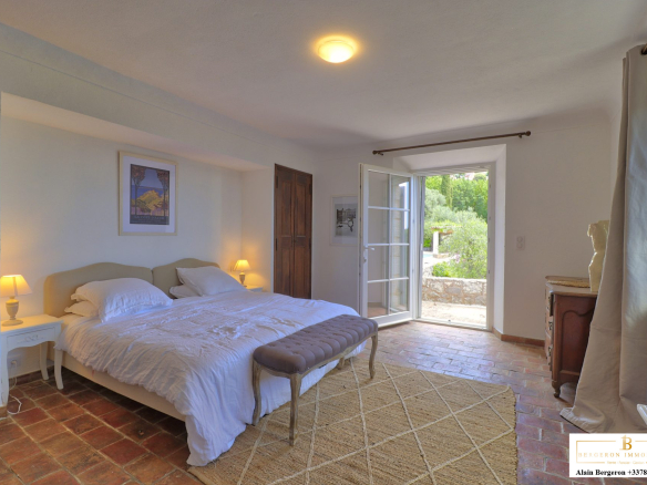 Chambre lumineuse d'une bastide provençale à Cabris, avec accès à un jardin.