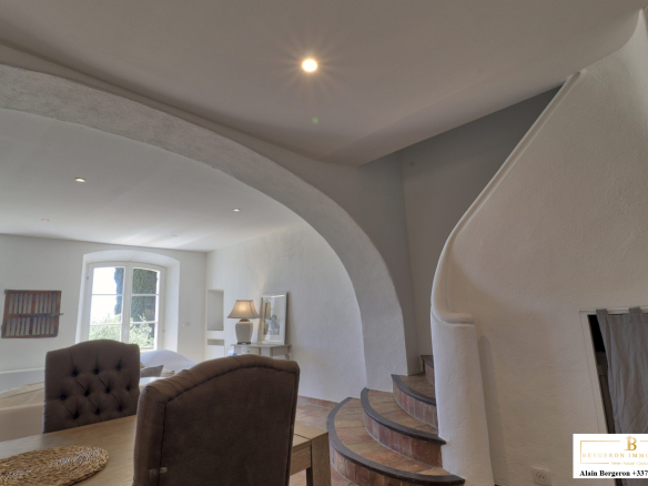 Intérieur d'une bastide provençale avec un escalier et des murs blancs.