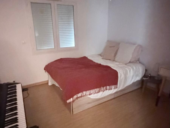 Chambre d'une villa à Spéracèdes avec lit et piano.