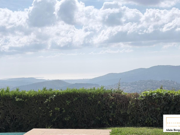 Vue panoramique depuis une villa à Spéracèdes avec des collines et la mer au loin.