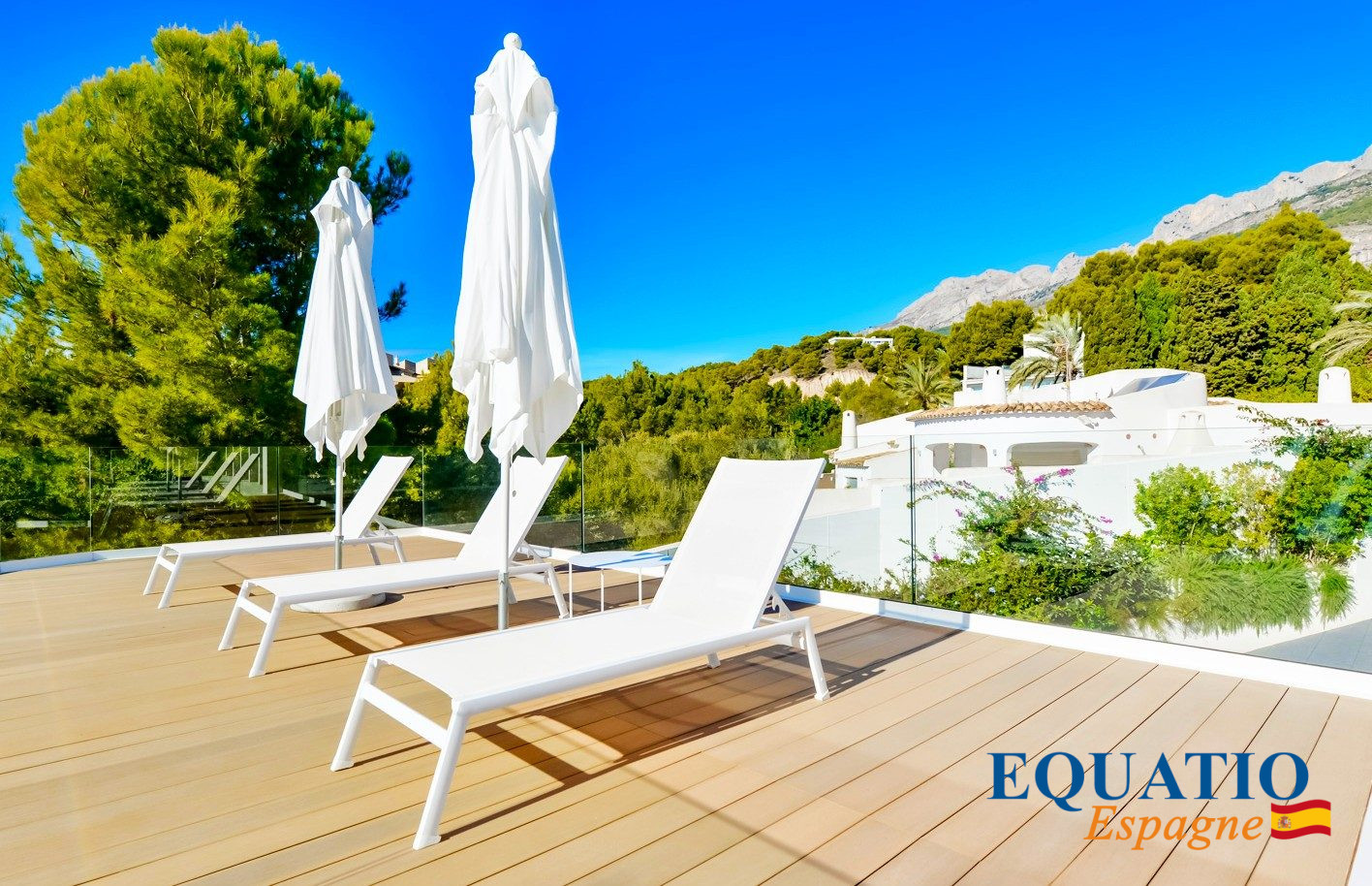 Terrasse de villa contemporaine à Altea Terrasse ensoleillée avec chaises longues et parasols, vue sur la nature à Altea, Espagne.
