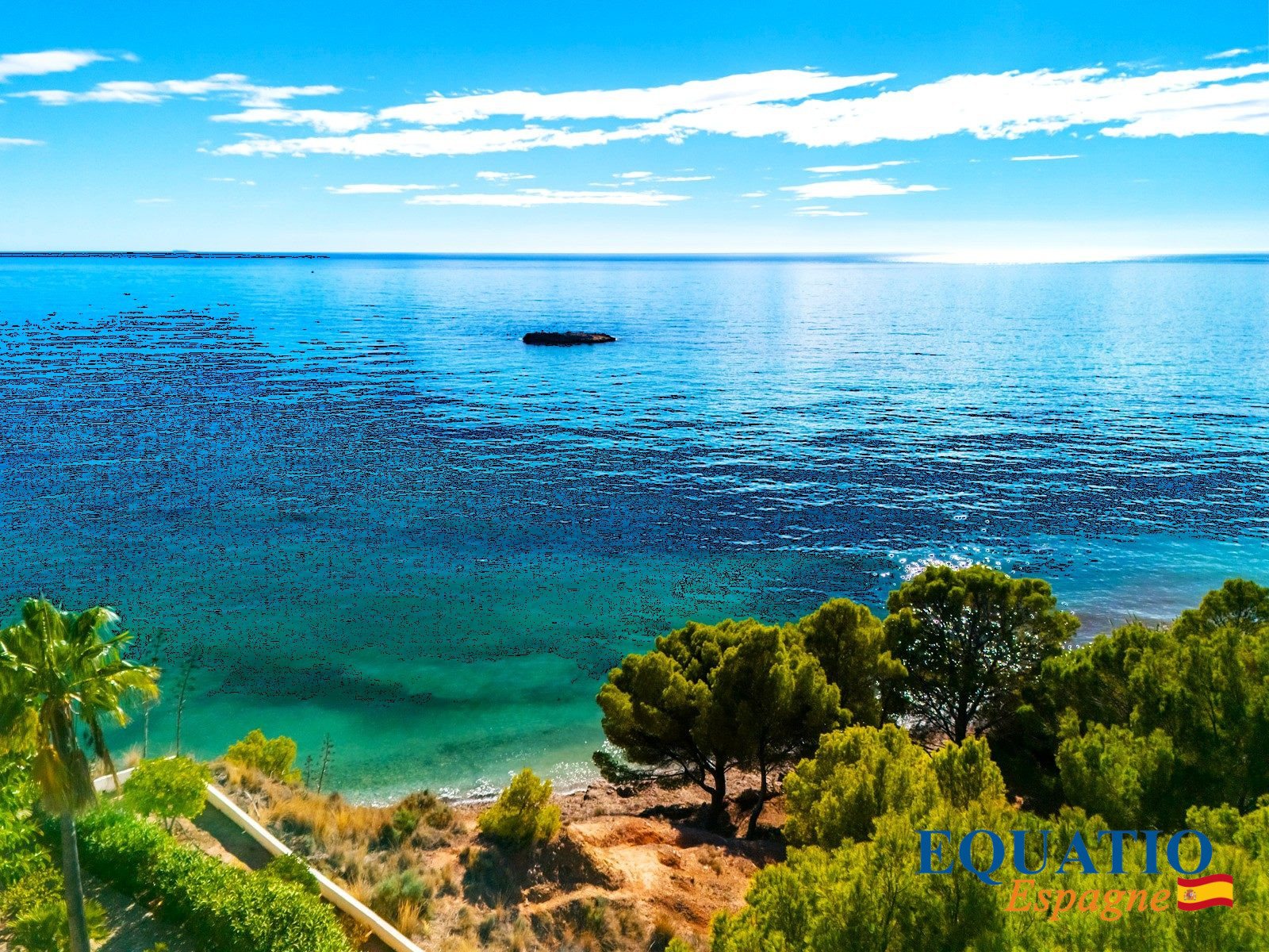 Villa contemporaine en bord de mer à Altea Vue sur la mer depuis une villa contemporaine à Altea, Espagne, avec des arbres au premier plan.