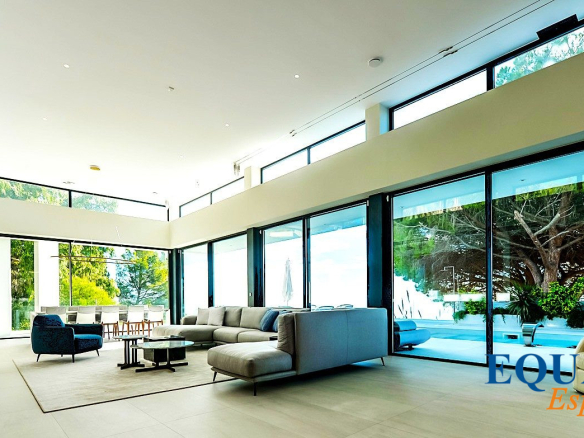 Intérieur d'une villa contemporaine à Altea avec vue sur la mer, salon spacieux et baies vitrées.
