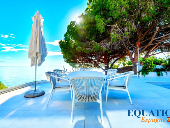 Terrasse d'une villa contemporaine en bord de mer à Altea, avec des chaises blanches et vue sur la mer.