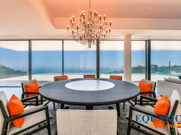 Intérieur moderne d'une villa à Altea avec vue sur la mer, salon lumineux et table ronde.