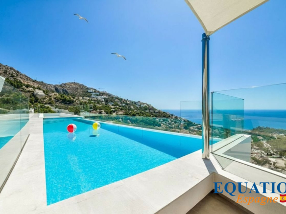 Vue d'une villa moderne avec piscine à débordement et vue sur la mer à Altea, Espagne.