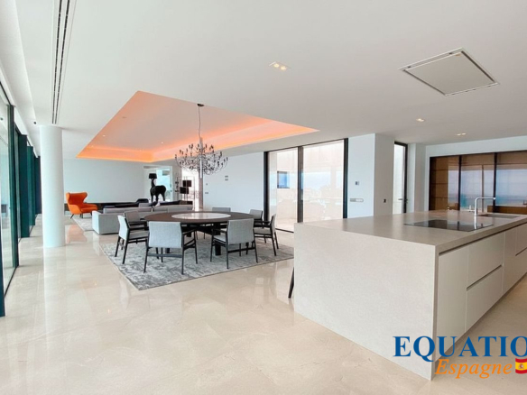 Intérieur moderne d'une villa à Altea avec vue sur la mer, salon et cuisine ouverts.