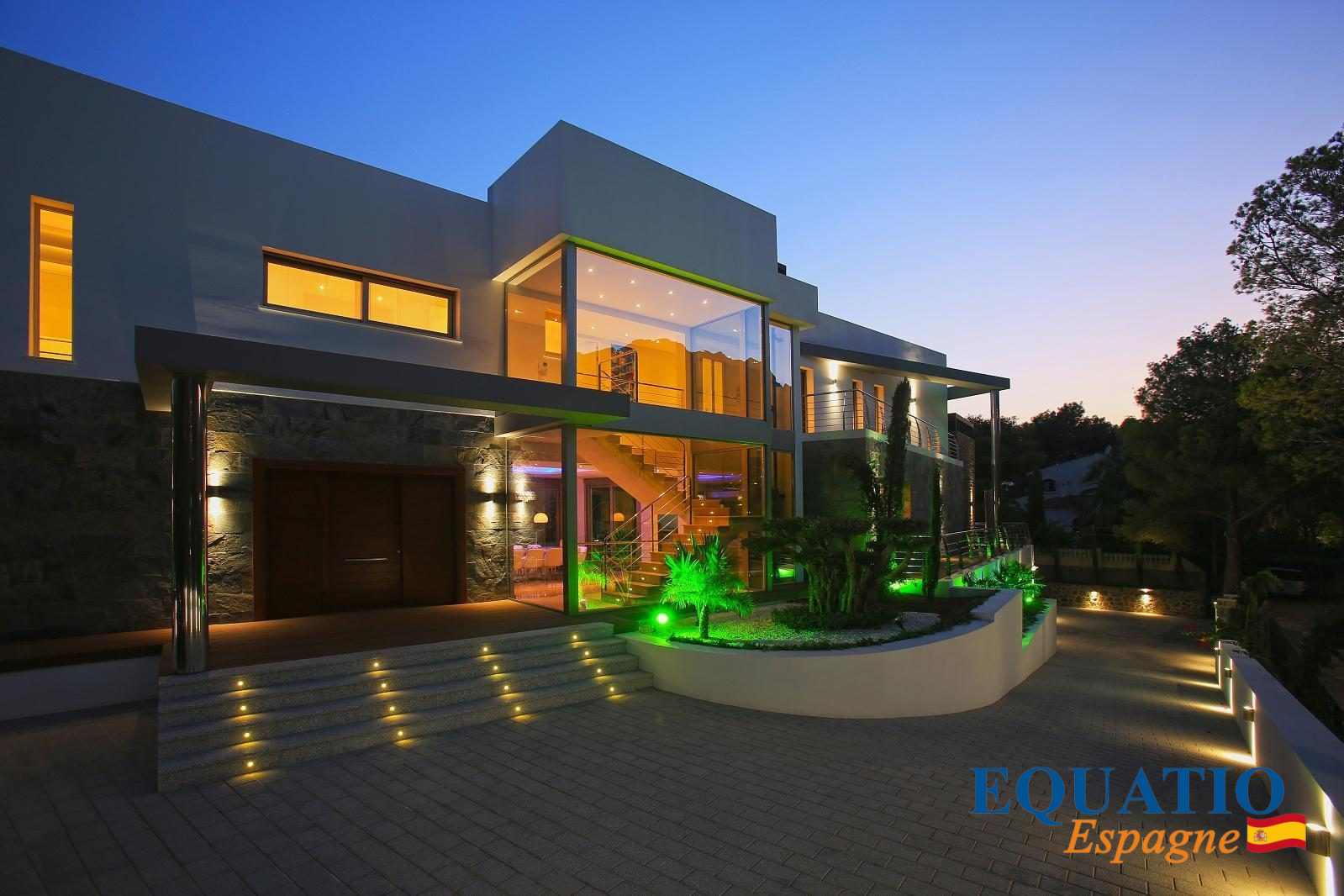 Villa moderne en première ligne de mer à Altea, Espagne, avec éclairage nocturne.