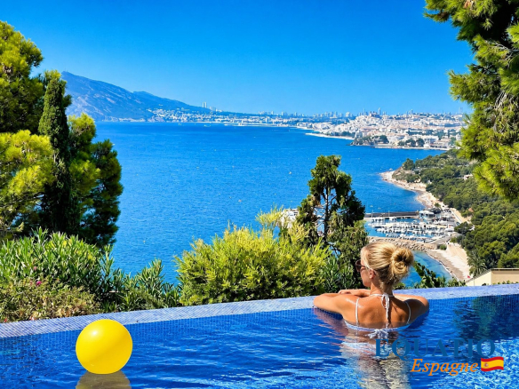 Vue d'une villa en première ligne de mer à Altea avec piscine et paysage côtier.