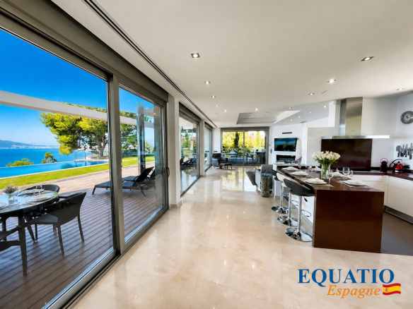 Intérieur moderne d'une villa à Altea avec vue sur la mer, cuisine ouverte et grandes baies vitrées.
