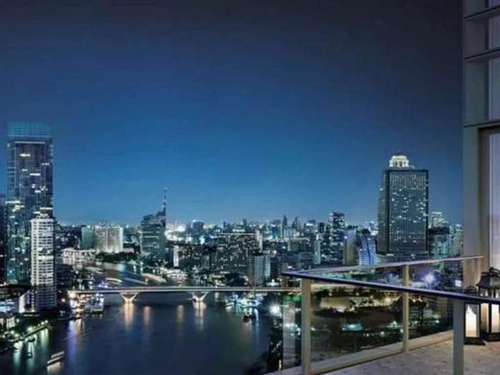 Night view of the city of Bangkok with skyscrapers and a river.