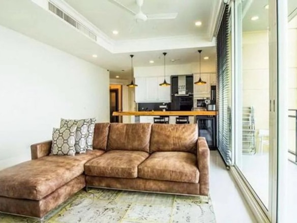 Salon moderne d'un appartement de luxe avec canapé et cuisine ouverte à Bangkok.
