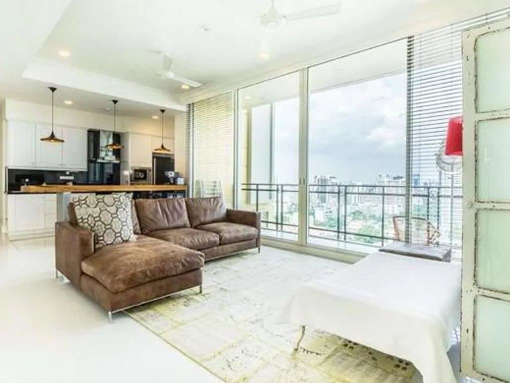 Intérieur d'un appartement de luxe à Bangkok avec un salon moderne et vue sur la ville.