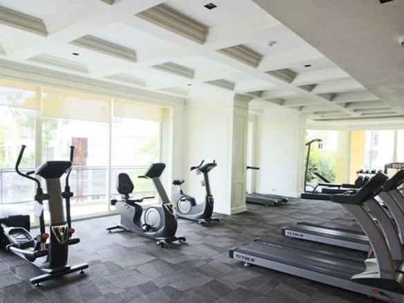 Salle de sport moderne avec équipements de fitness dans un appartement de luxe à Bangkok.