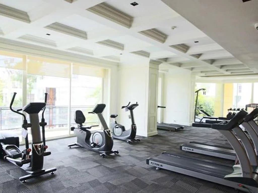 Salle de sport moderne avec équipements de fitness dans un appartement de luxe à Bangkok.