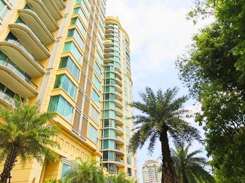 Vue extérieure de l'appartement de luxe Royce Private Residences à Bangkok avec des palmiers.