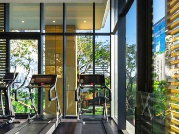 Modern gym with treadmill and outdoor view in Bangkok.