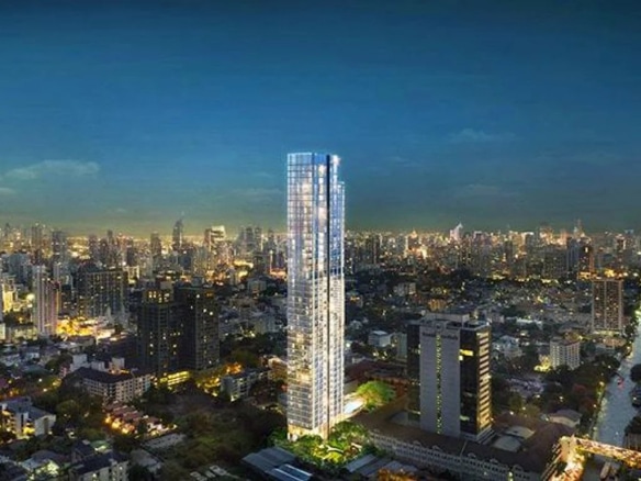 View of a modern building in Bangkok with night lighting and the city in the background.