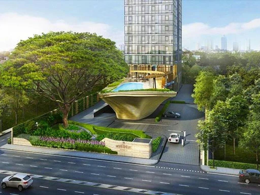 Exterior view of a modern apartment in Bangkok with a swimming pool and garden.