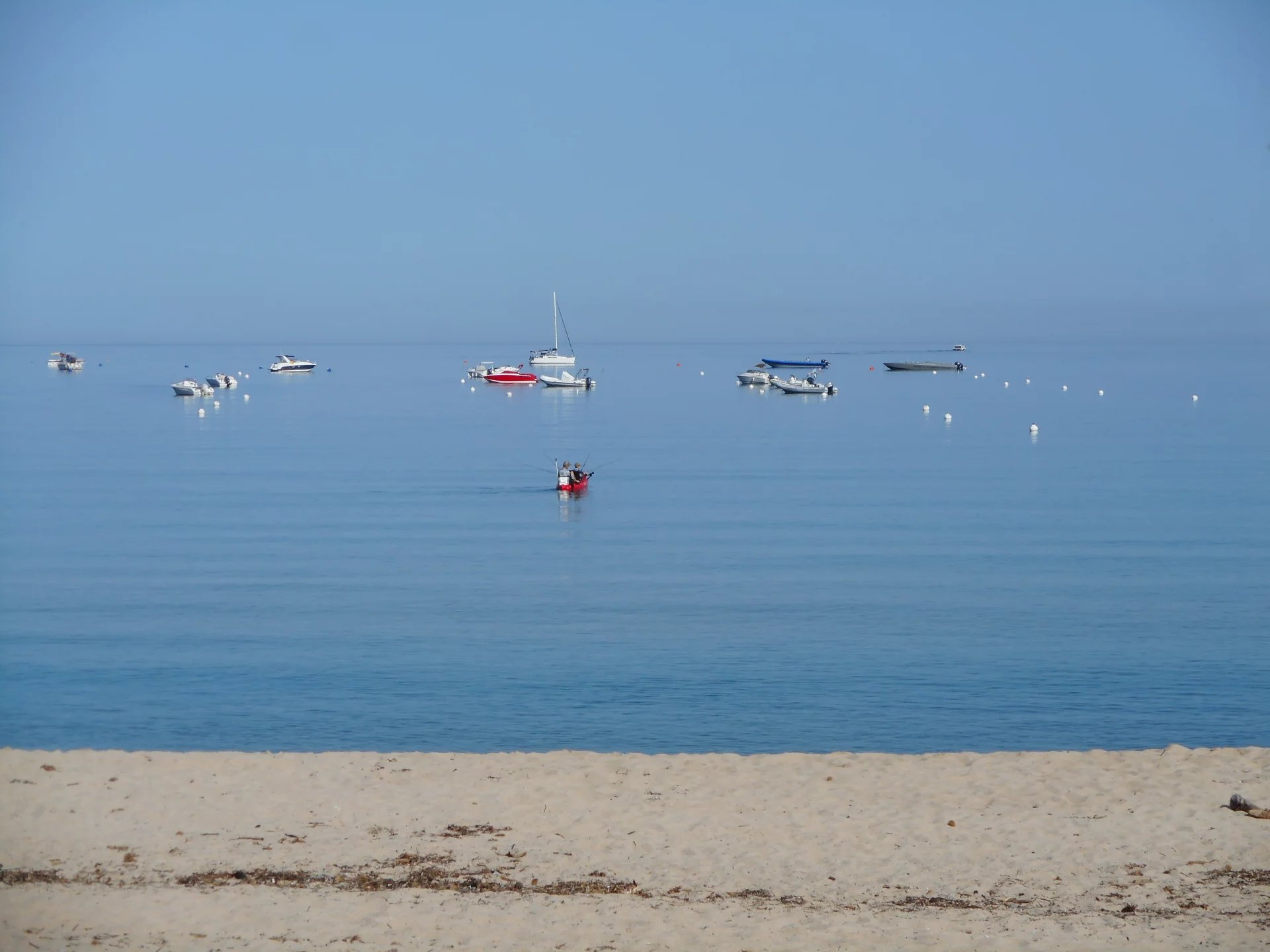 Plage de Calcatoggio Vue de la plage de Calcatoggio avec des bateaux au large et une mer calme